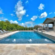 Big swimming pool with lounge chairs and water spray features
