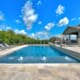 Big swimming pool with lounge chairs and water spray features