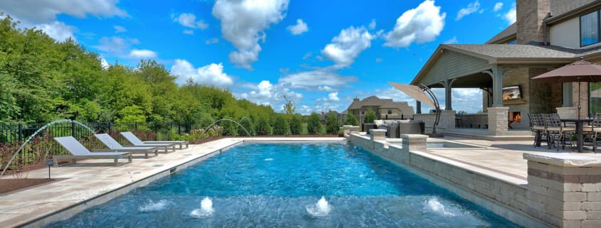 Big swimming pool with lounge chairs and water spray features