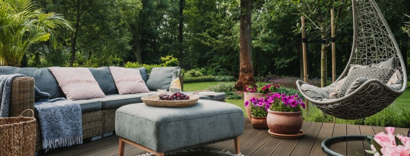 Garden patio decorated with Scandinavian wicker sofa and coffee table