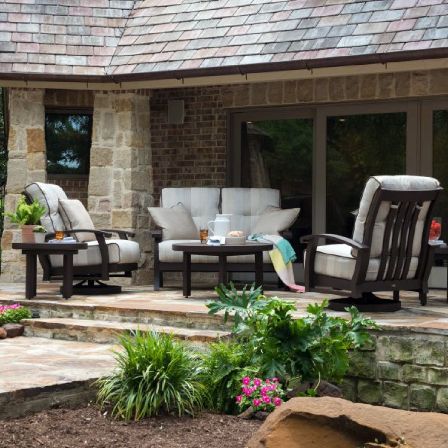 Stylish cushioned outdoor seating set on a stone patio, perfect for relaxing and searching for Patio Furniture stores near me.