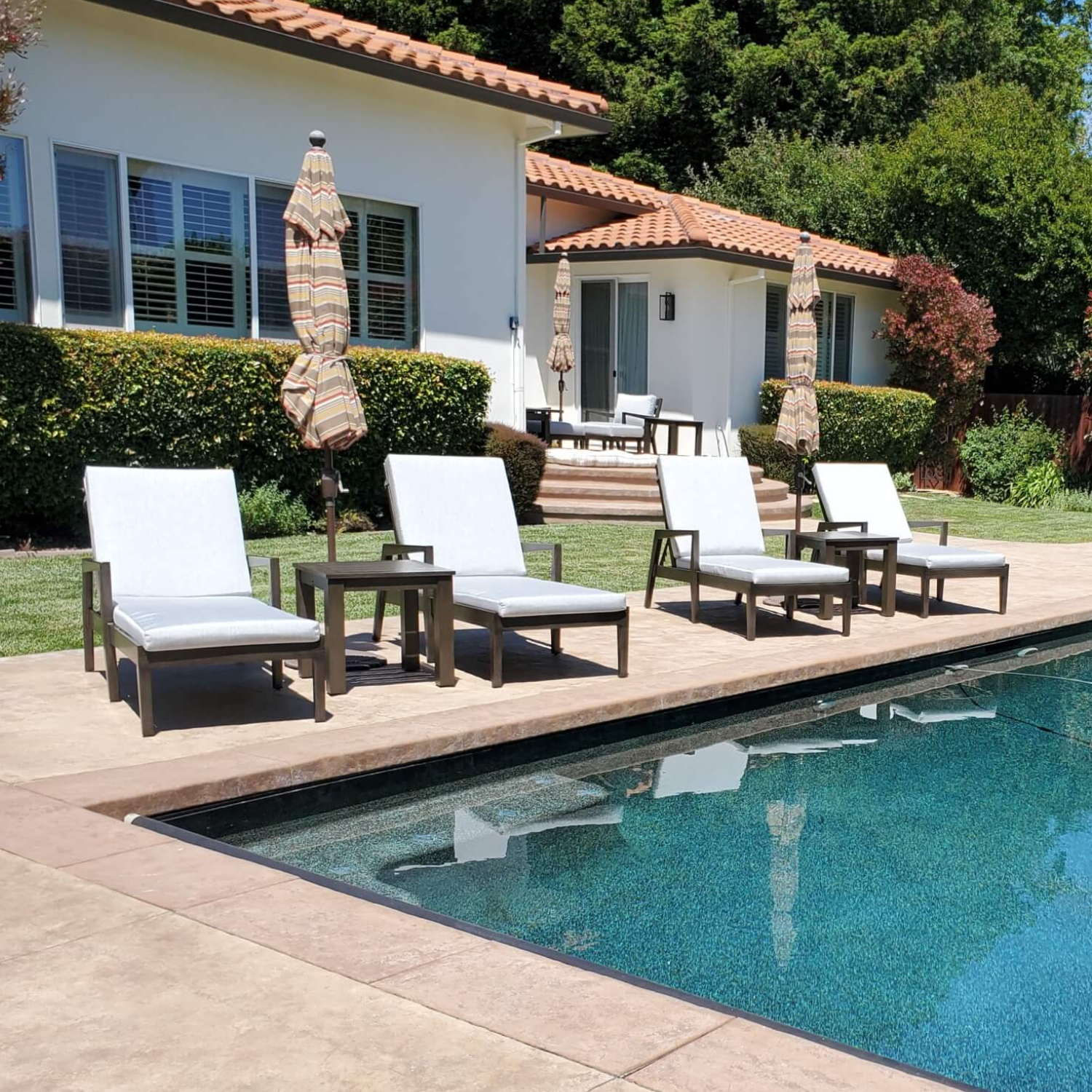 Comfortable white cushioned lounge chairs by the poolside, a stylish selection for Patio Furniture near me.